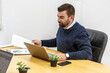 © Juan Algar - Professional man working in a coworking space with documents and laptop