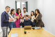 © Juan Algar - Group of people celebrating a success in a modern coworking space during a meeting
