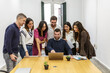 © Juan Algar - Group of coworkers collaborating in shared workspace with laptop