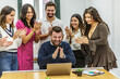 © Juan Algar - Group of people celebrating a coworking space achievement with smiles and applause