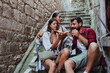 © Novak - Three young tourists enjoying pizza while sitting on stone stairs in the old town