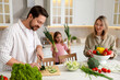 © New Africa - Happy family cooking together at table in kitchen
