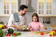 © New Africa - Happy father cooking together with his daughter at table in kitchen