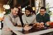 © Novak - Group of diverse friends sitting in a restaurant, drinking beer and talking