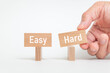 © hogehoge511 - There is wood block with the word Easy or Hard. It is as an eye-catching image.