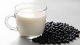Fresh organic black soy milk in glass cup with heap of black soybeans on white background for health