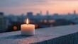 © piyawat - Single white candle burning brightly on concrete with cityscape background in peaceful sunrise/sunset ambiance.