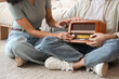© Pixel-Shot - Young couple turning on retro radio receiver at home