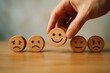 © ParinApril - Hand selecting a cheerful emoji from a range of expressive faces, symbolizing emotional well-being, choice, and the importance of positive outlooks in personal and professional contexts.