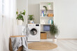 © Pixel-Shot - Interior of light laundry room with washing machine, shelf unit and plants