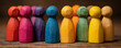 © Atchariya63 - Wooden figurine group in vibrant colors standing on wooden surface, symbolizing diversity and unity with warm lighting creating cozy atmosphere