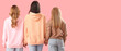 © Pixel-Shot - Women holding hands on pink background, back view