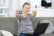 © auremar - woman using laptop at home holding padlock and bank card