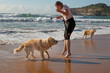 © Austockphoto - happy dog playing on the beach with owner