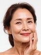 © Johannes - closeup cut portrait of happy middle aged mature asian woman senior older 50 year lady looking at camera touching her face isolated on white ads of eye lifting anti wrinkle skin care cream no logos n