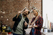 © Westend61 - Couple smiling and planning renovation with measuring tape at construction site