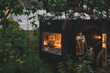 © Q88 - Cozy cabin retreat nestled amongst lush greenery illuminated warmly inside a nature escape