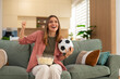 © Dexon Dee - Woman cheering watching football game at home