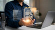 © Lee - Businessman holding a glowing virtual contract with a shield icon,symbolizing secure digital agreements,trustworthy insurance policy,guaranteed protection for corporate safety
