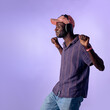 © Lomb - Young black man listening to music with headphones dancing in studio with copy space
