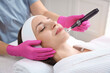 © New Africa - Woman undergoing microneedling procedure in beauty salon, closeup