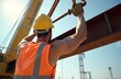 © Pete - Construction worker wears hard hat and high-visibility vest. Muscular man directs heavy steel beam lifting with crane hook. Focus on strength and site safety.