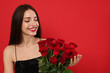 © New Africa - St. Valentine's Day. Beautiful woman with bouquet of roses on red background. Space for text