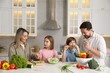 © New Africa - Happy family cooking together at table in kitchen