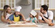 © New Africa - Happy family cooking together at table in kitchen