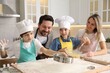 © New Africa - Happy family cooking together at table in kitchen