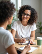 © Pete - Woman with glasses smiles while writing in notebook. Person receives counseling and support in office setting. Client discusses problems with therapist or coach during meeting.