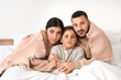© Pixel-Shot - Frozen family under blanket with lack of heating in bedroom