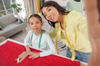 © Pixel-Shot - Happy Asian mother and her daughter taking selfie in sewing studio