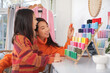 © Pixel-Shot - Happy Asian mother and her daughter choosing colourful thread spools in sewing studio