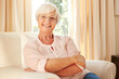 © peopleimages.com - Elderly woman, portrait and relax in home with smile, comfort and security in retirement. Senior person, happy and glasses in living room for wellness, rest and satisfied with pension in Australia