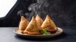 © Atif - Steaming hot samosas with dipping sauce on plate