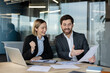 © Liubomir - Business colleagues at a modern office table reviewing documents and data charts, sharing a moment of success and achievement while working on a laptop