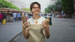 © Krakenimages.com - Woman in apron holds two ceramic bottles with bare hands, inspecting them in a street market; serenity.