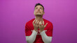 © Krakenimages.com - Hispanic man expressing emotion in volunteer t-shirt against vibrant pink background in isolated studio shot displaying frustration.