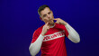 © Krakenimages.com - Man in volunteer shirt playfully posing against vibrant blue background showing humor fun volunteerism.