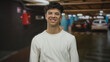 © Krakenimages.com - Young man with folded arms beside car in indoor parking building wearing glasses and ribbed sweater; confidence.
