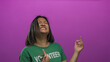 © Krakenimages.com - Young chinese woman playfully mimicking guitar playing with enthusiasm, wearing a green volunteer t-shirt against a vibrant pink wall in a joyful expression of creativity.