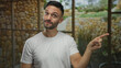 © Krakenimages.com - Young man gesturing in a rustic mediterranean house creates a dynamic scene with stone walls and outdoor garden view captured vividly.