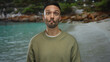 © Krakenimages.com - Young man making a playful expression at the beach with the sea in the background, emphasizing the relaxing seaside atmosphere and casual outdoor setting in sunny weather.