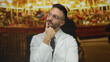 © Krakenimages.com - Young man in a white coat and glasses stands thoughtfully against a vibrant carousel backdrop at a fair, capturing a moment of introspection and celebration.