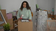 © Krakenimages.com - Woman organizing moving supplies in a new home surrounded by boxes and furniture in living room indicating a fresh start in life.