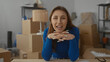 © Krakenimages.com - Woman smiling in new home surrounded by cardboard boxes in cozy living room, embodying excitement and anticipation during moving day.