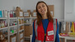 © Krakenimages.com - Volunteer woman smiling indoors at a charity center filled with donation supplies and organized storage shelves highlighting community spirit and humanitarian efforts.