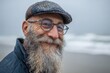 © Popelniushka - Joyful Bearded Man in Cap and Glasses Enjoying a Day at the Beach: A Close-Up Portrait in Nature