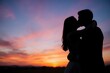 © Studicon - Silhouette of a loving couple kissing against a vibrant sunset sky